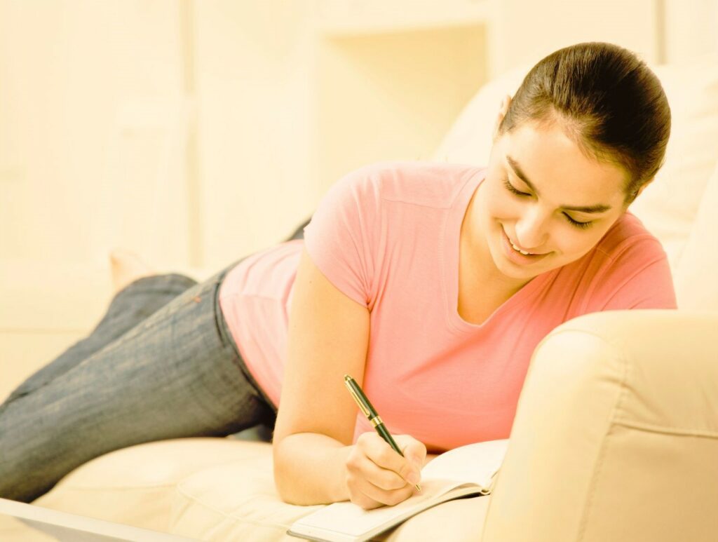 Il s'agit d'une femme qui écrit dans un journal et fait des exercices de développement personnel pour développer sa confiance en elle