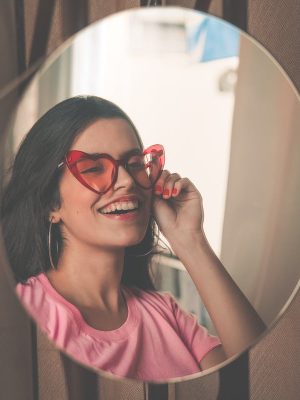 Une femme se regarde dans le miroir et souris